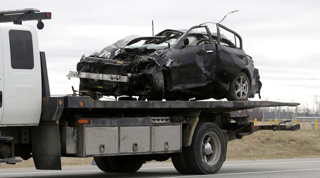 An Infiniti-brand car involved in a fatal early morning single-vehicle collision on Fallowfield Rd. at Eagleson Rd. is removed from the scene on a flatbed truck, Sunday, April 26, 2015. Photo by Mike Carroccetto.