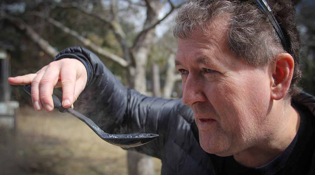 Stittsville resident Al Caughey tastes his boiling tree sap as he boils it down in his back yard. Photo by Barry Gray.