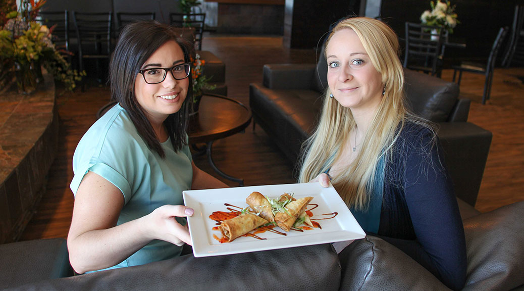 ALE general manager Sarah St. Michael (left) with Nicolle Carson, assistant / bar manager. They're are holding ALE's crab spring rolls. Photo by Barry Gray.