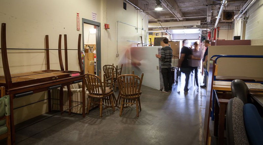 Volunteers move and sort donated furniture in the Matthew House warehouse. Photo via Matthew House