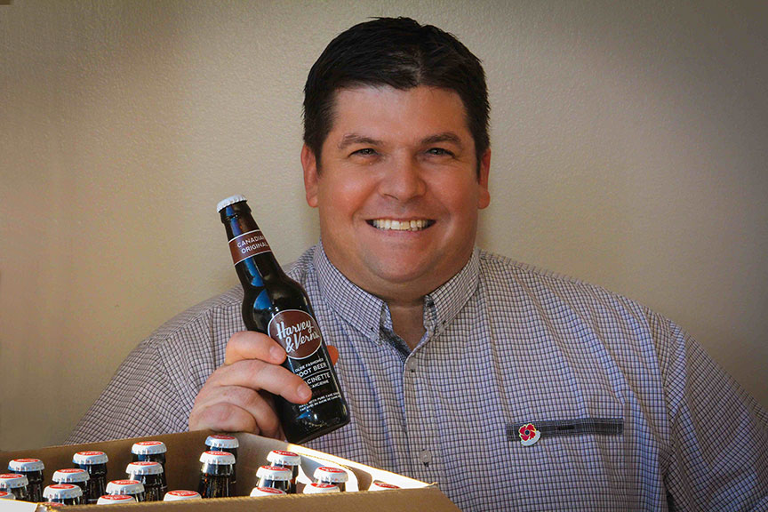Paul Meek holds up a bottle of Harvey & Vern's root beer at Quitters Coffee, November 2014. Photo by Barry Gray.