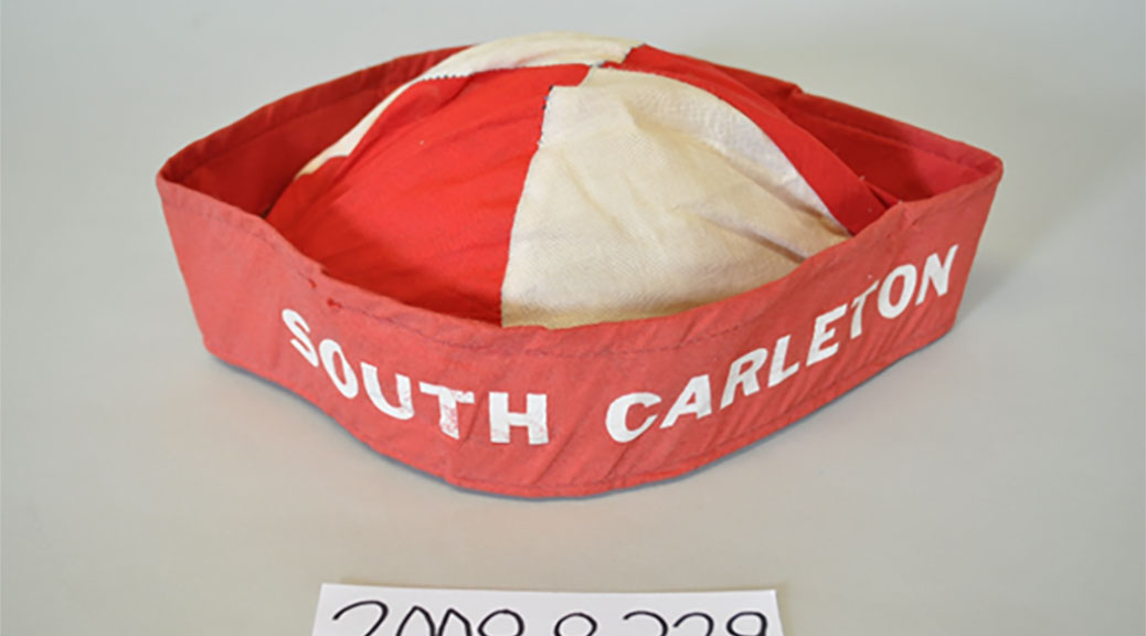 South Carleton Beanie: One fabric beenie, red and white cap, stiffened rim with "South Carleton" written in white capital letters.