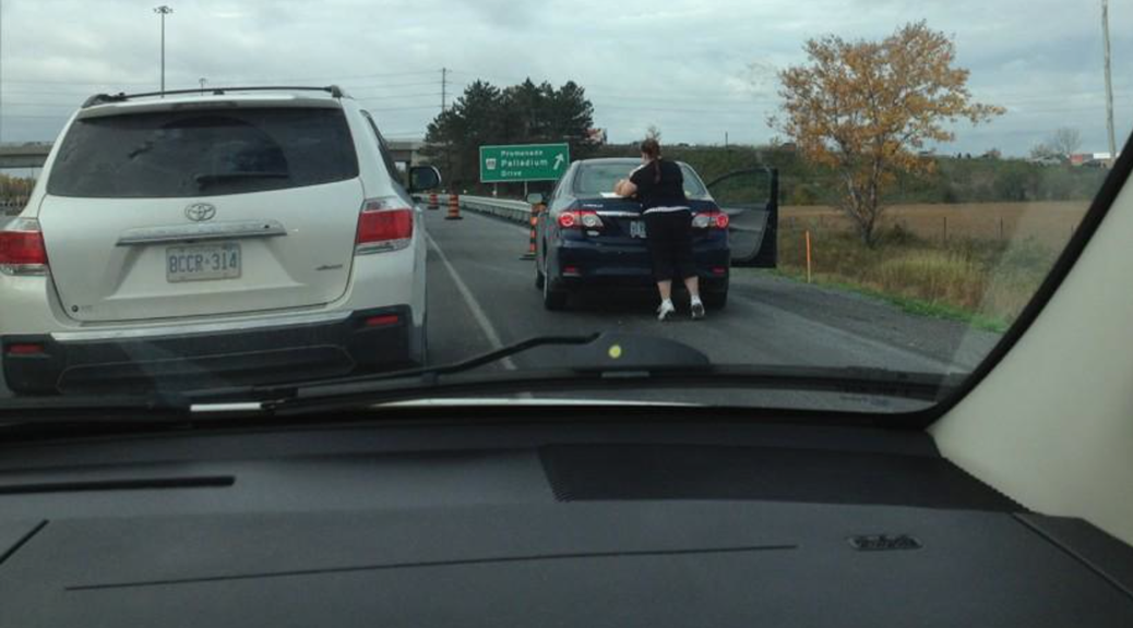 An unidentified woman changes a diaper while parked on the side of the Queensway, en route to Tanger Outlets on opening day. Photo via @PaulaMcCooey on Twitter.