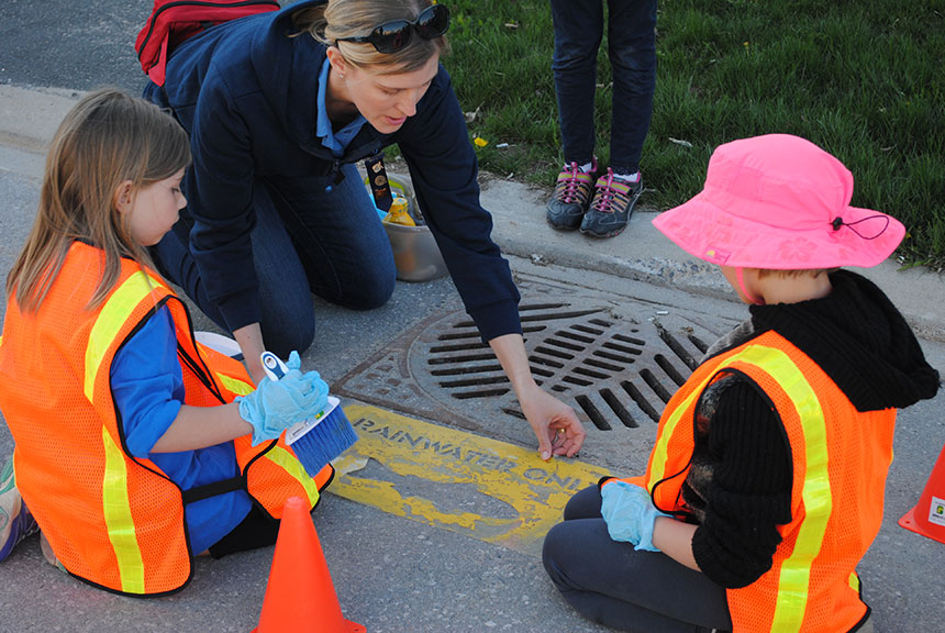 Brownies paint yellow fish stencils in the Fairwinds neighbourhood. Photo via Kerry Reimer